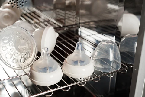 Bình sữa và núm ti được đặt trong máy rửa bát